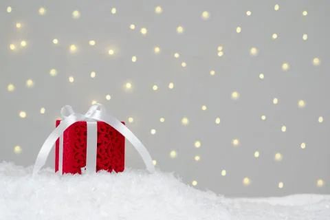 Red gift on white snow. Background with bokeh Stock-Fotos