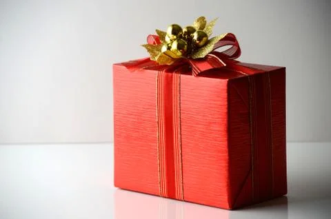 Red gift-wrapped box on grey background with copy space Stock Photos