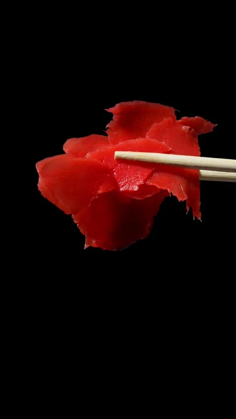 Red ginger on a black background in wooden sticks. A spice for sushi. Stock Footage 305247799