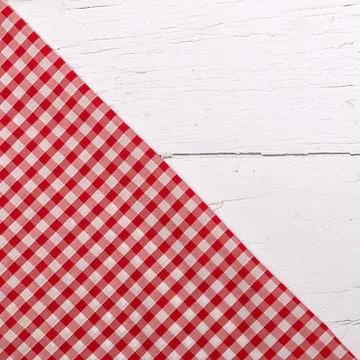 Red gingham table cloth on corner of white wooden table.  Flat lay with cop.. Stock Photos