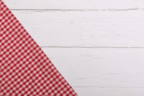 Red gingham table cloth on corner of white wooden table.  Flat lay with cop.. Stock Photos
