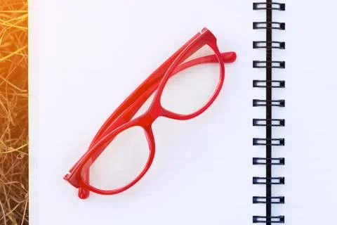 Red Glasses on Open Blank Notebook in Field with Sunlight Stock Photos