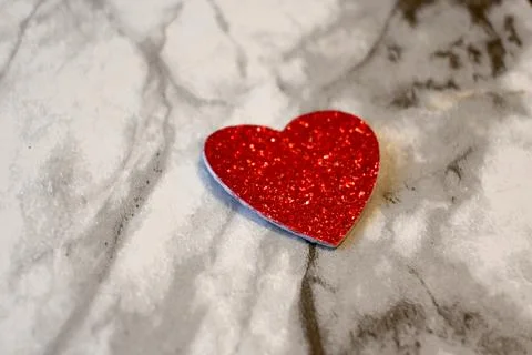 Red glitter heart on marble surface Stock Photos
