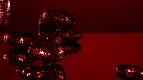 Red glitter hearts falling on reflective surface Video stock 327122658