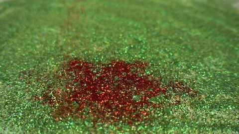 A red glitters falling onto the surface consisting of green spangles in the slow Stock Footage 110917678