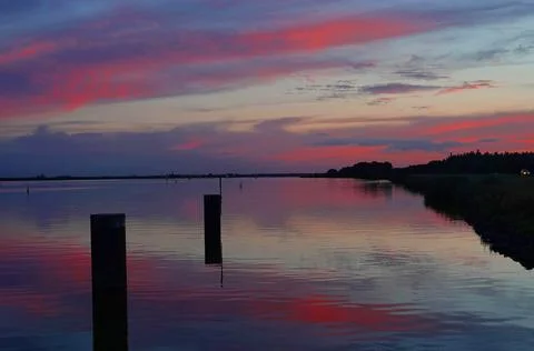 Red glowing clouds reflected in a lake Stock Photos