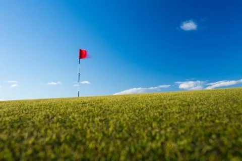 Red golf flag on a golf course, moving in the wind (motion blurr Stock-Fotos