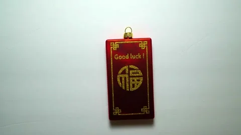 Red good luck charm sliding into and out of view Stock Footage 256956461
