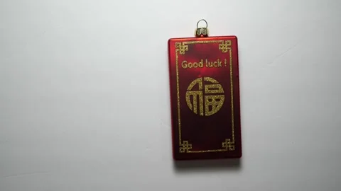 Red good luck charm sliding into and out of view Stock Footage 256956476