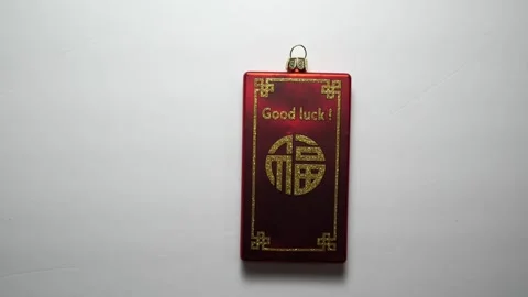 Red good luck charm sliding into and out of view Stock Footage 256956480