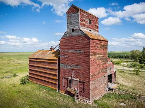 Red grain elevator with a ladder leaning against it Stock Photos