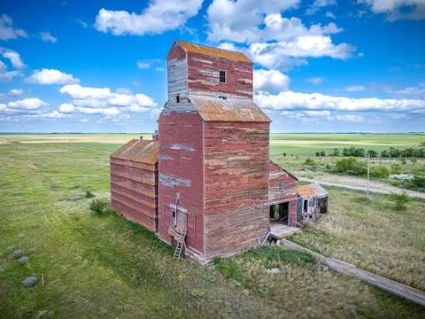 Red grain elevator is in the middle of a field Stock Photos