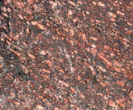 Red granite texture background with small crystals and inclusions, close up Stock Photos