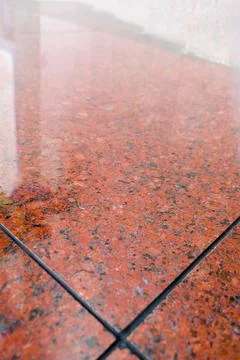 Red granite tile flooring texture with dark speckles and grout lines Stock Photos