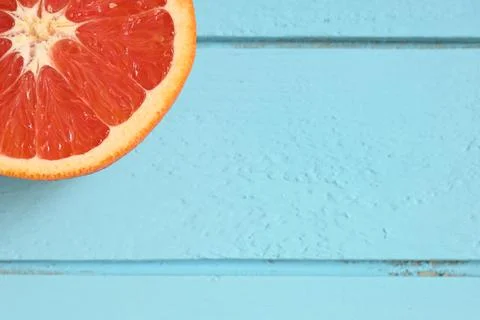 Red grapefruit cut in half on a blue wooden rustic background Stock Photos