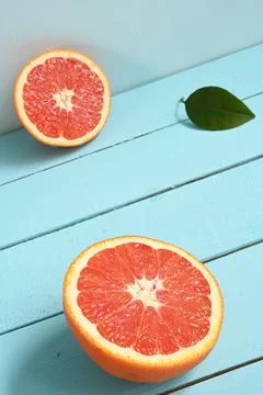 Red grapefruit cut in half on a blue wooden rustic background Stock Photos