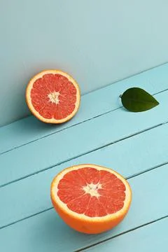 Red grapefruit cut in half on a blue wooden rustic background Stock Photos