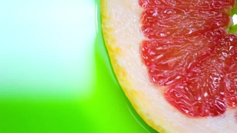 Red grapefruit rotates on a green background copy space 動画素材 135331807