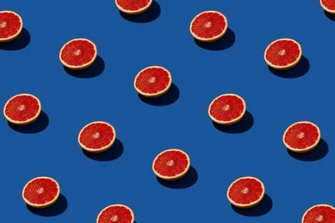Red grapefruit sunlit pattern on a deep blue background. Stock Photos