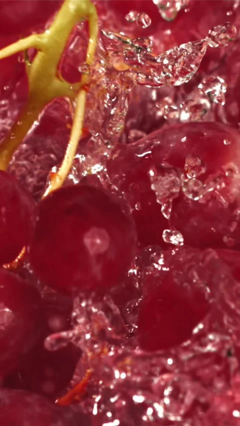 Red grapes fall with splashes into the water. Top view. Filmed on a high-speed Stock Footage 335317211