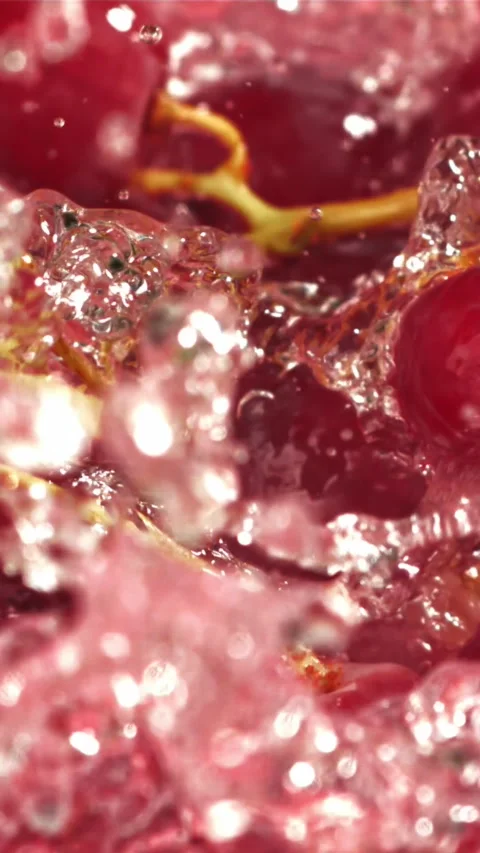 Red grapes fall with splashes into the water. Top view. Filmed on a high-speed Stock Footage 335317983