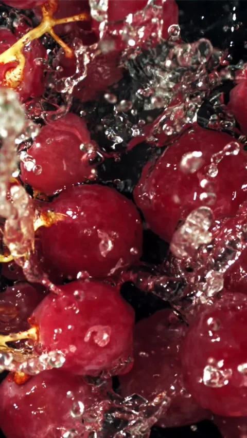 Red grapes fall with splashes into the water. Top view. Filmed on a high-speed Stock Footage 335319835