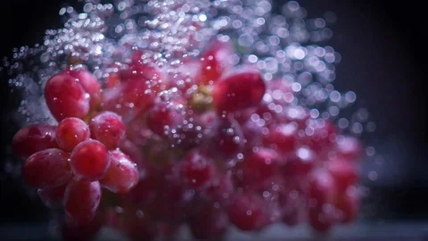 Red grapes fall into water with splashes super slow motion shot Video stock 122979674
