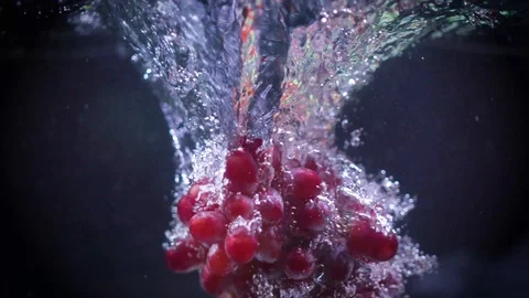 Red grapes fall into water with splashes super slow motion shot Video stock 122979704