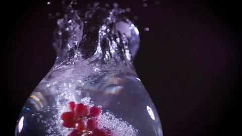 Red grapes fall into water with splashes super slow motion shot Video stock 122982095