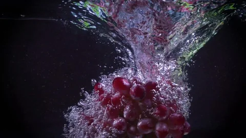 Red grapes fall into water with splashes super slow motion shot Stock Footage 122982172