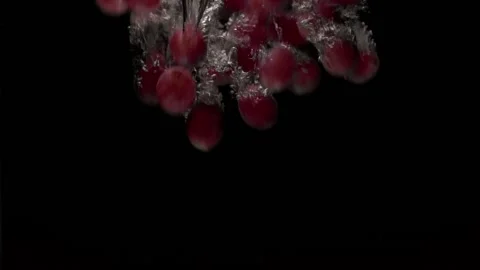 Red grapes will fall into the water in slow motion. on a black background Stock Footage 131037363