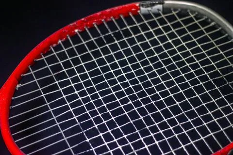 Red - gray racket with white strings on a black background Photos
