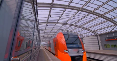 Red-gray train arrives at ground station of the metro Stock Footage 119630462