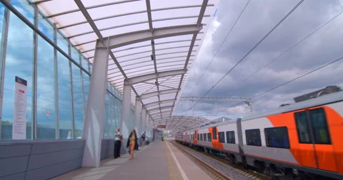 Red-gray train arrives at ground station of the metro Stock Footage 119632056