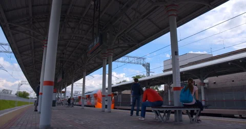 Red-gray train departs from the ground metro station from a neighboring platform Stock Footage 119636206