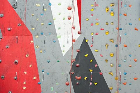 Red-gray wall of climbing wall, with ledges and ropes with carbines Foto stock