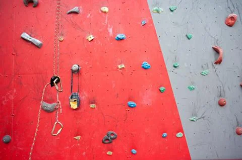 Red-gray wall of climbing wall, with ledges and ropes with carbines Stock-Fotos