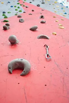 Red-gray wall of climbing wall, with ledges and ropes with carbines Stock Photos