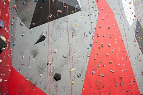 Red-gray wall of climbing wall, with ledges and ropes with carbines Stock-Fotos
