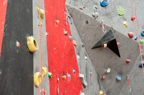 Red-gray wall of climbing wall, with ledges and ropes with carbines Foto stock