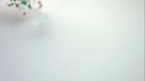 Red Green And White Candy Fall And Slide Across White Table Stock Footage 70333315
