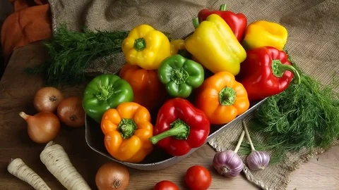 Red, green and yellow sweet bell peppers on table, Stock Footage
