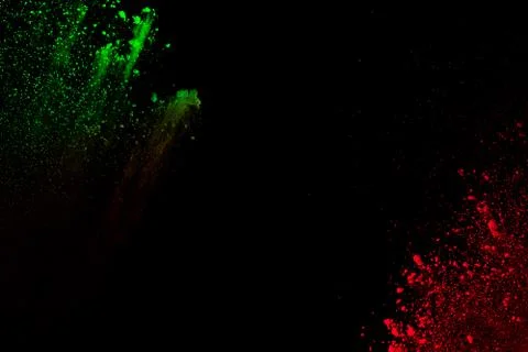 Red green powder explosion cloud on black background. Stock Photos