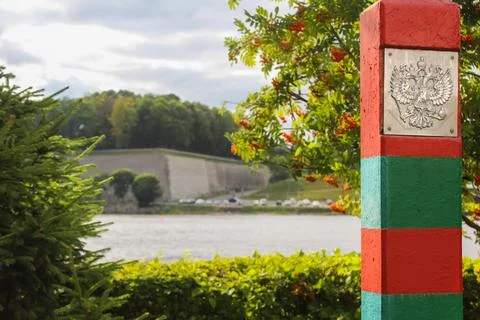 Red-green striped border post with a coat of arms of Russia. Double-headed eagle Stock Photos