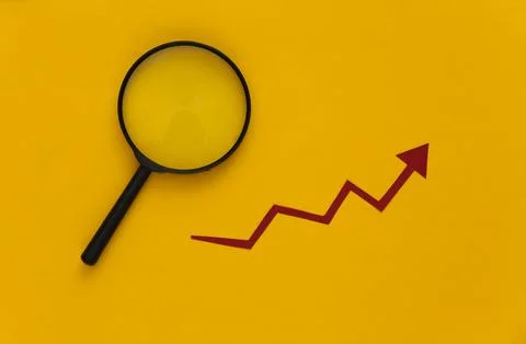 Red growth arrow, magnifier on yellow background. Arrow graph going up. The e Photos