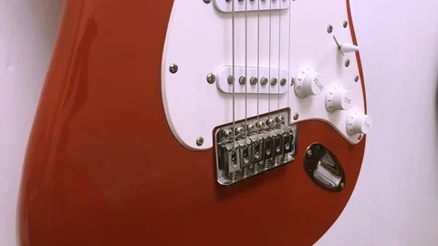 Red guitar on a white wall 4K Stock Footage 100684347