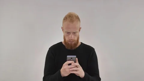 Red guy holding the phone in his hands and typing SMS Stock Footage 81774282