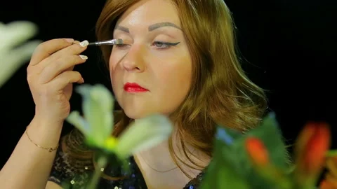 Red-haired actress in the dressing room makes eye makeup with silver sparkles 库存影片 107786780