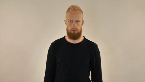 Red-haired bearded man shows his hand a stop sign Stock Footage 117416544