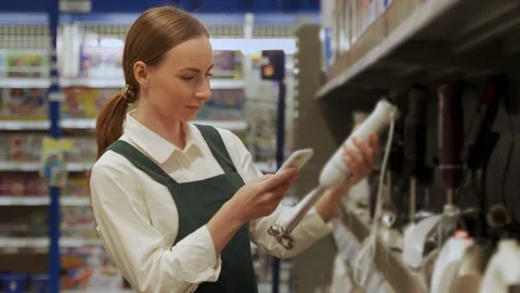 Red-haired customer examines blender in supermarket closeup Video stock 202305749